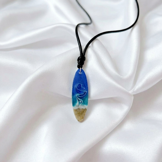 Adjustable rope necklace with handcrafted resin surfboard pendant filled with South African beach sand